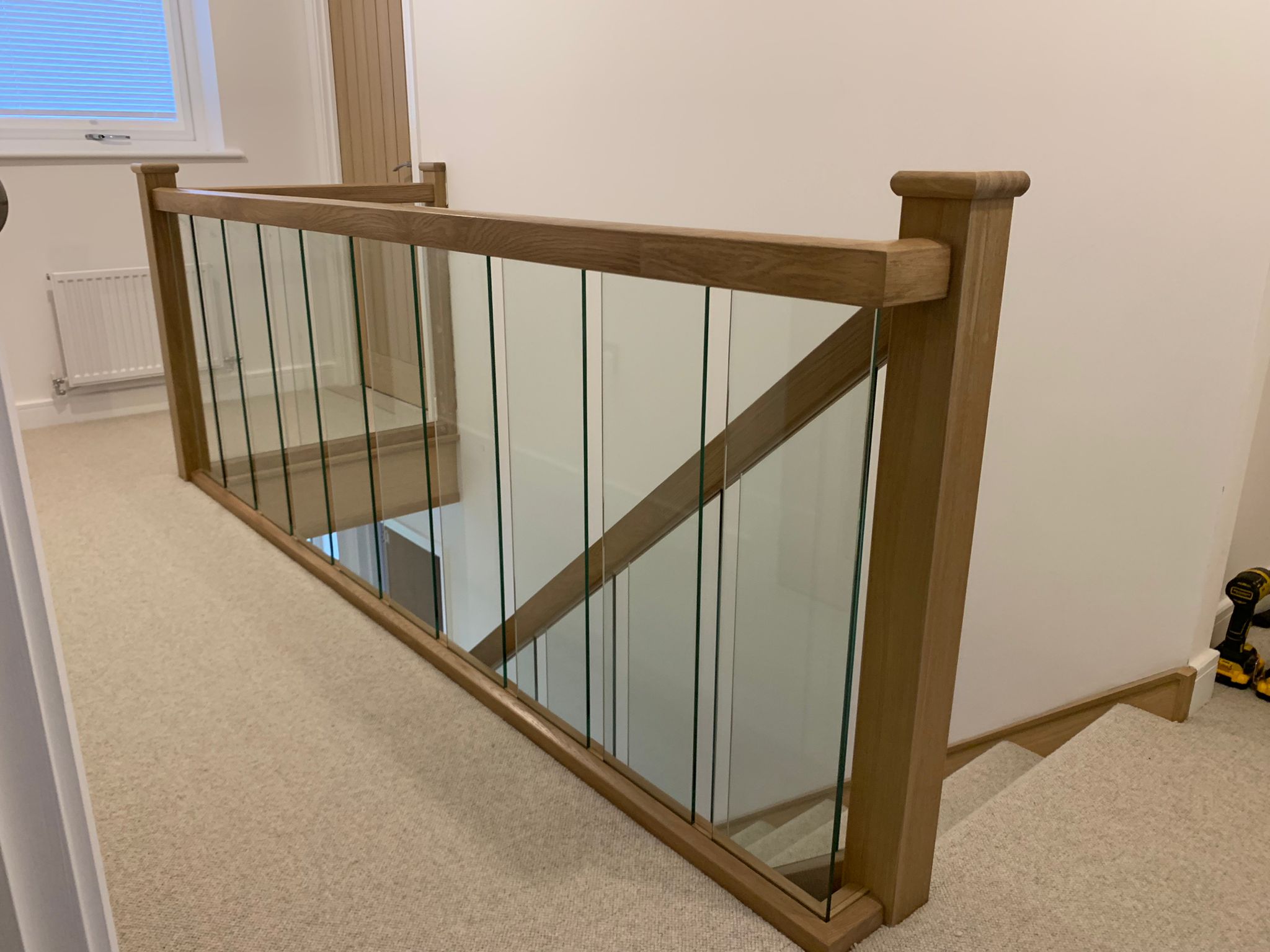 A landing with an oak and glass balustrade