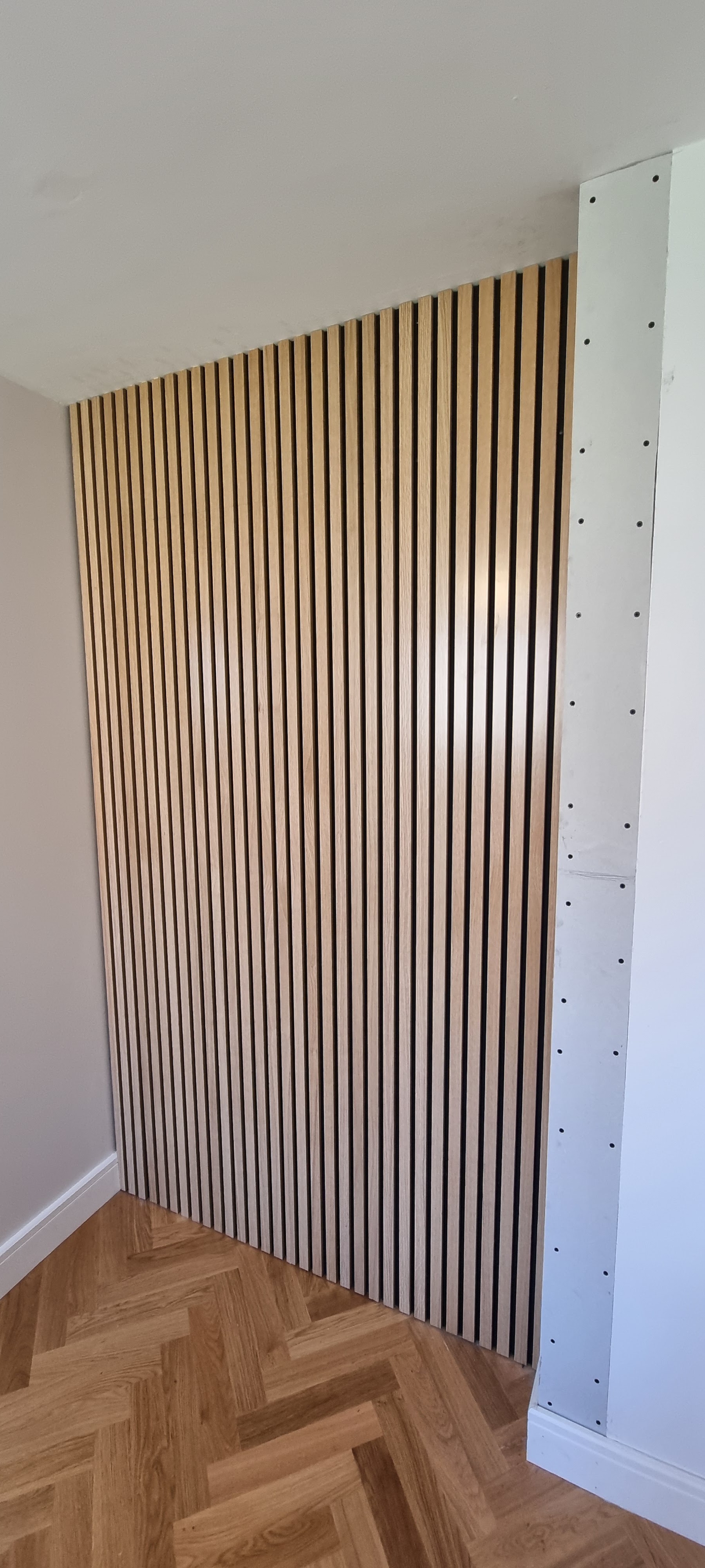 An oak slat wall panel over a herringbone floor